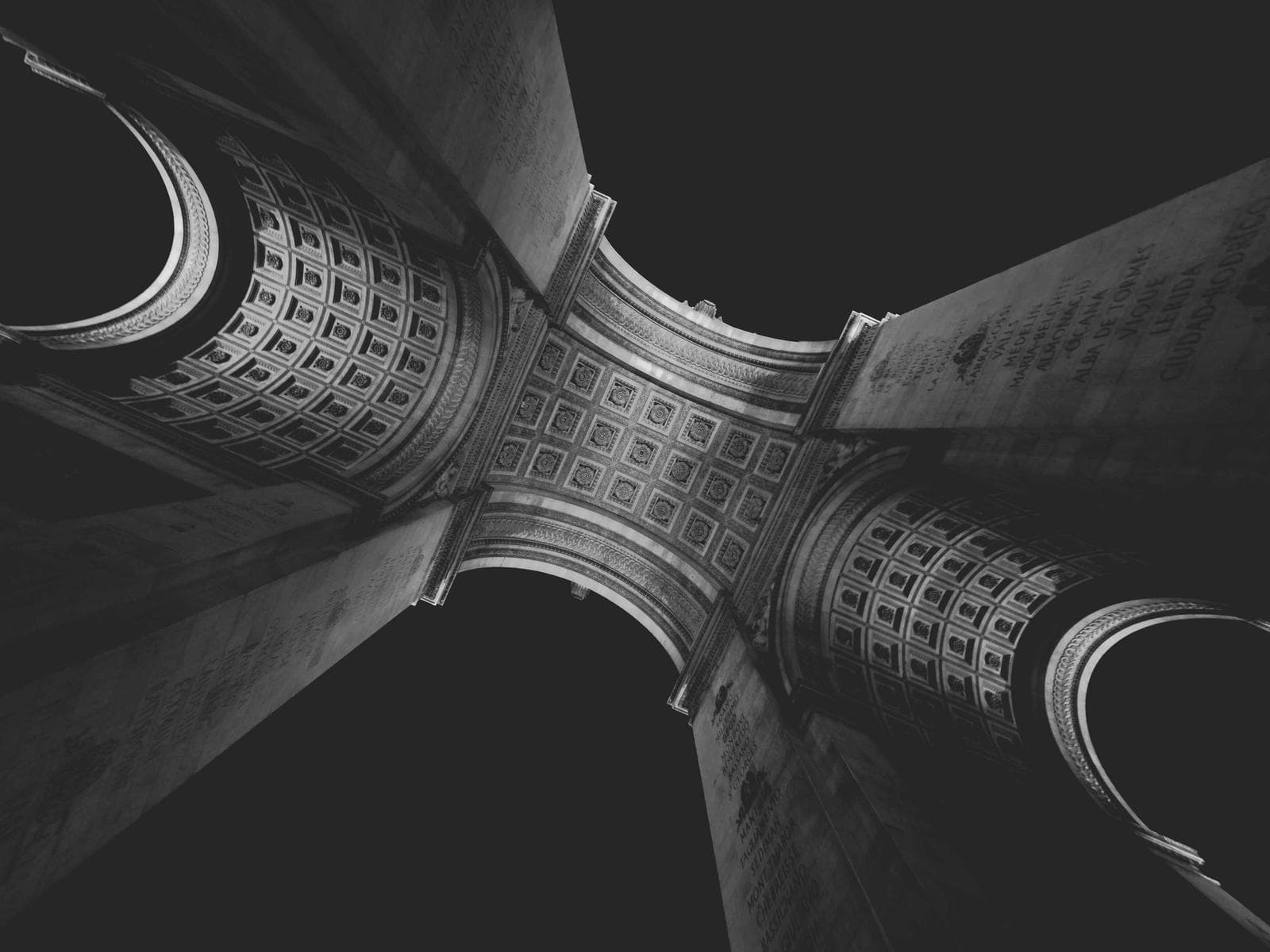 黑白摄影下的建筑柱头雕饰特写，展现重复的几何纹样